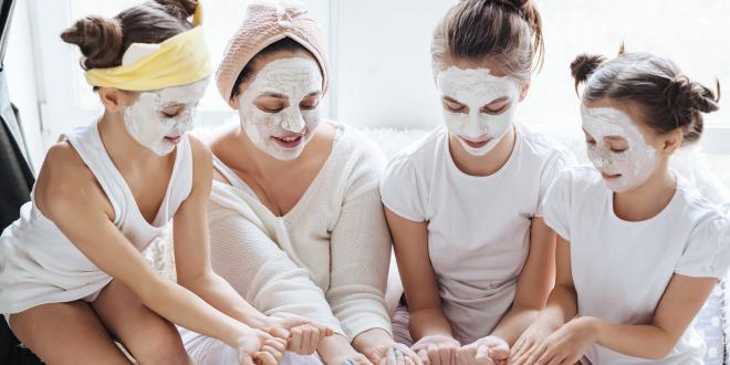 a family of young women applying skin care products