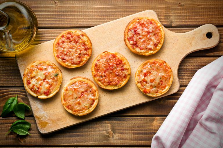 mini pizzas on a cutting board